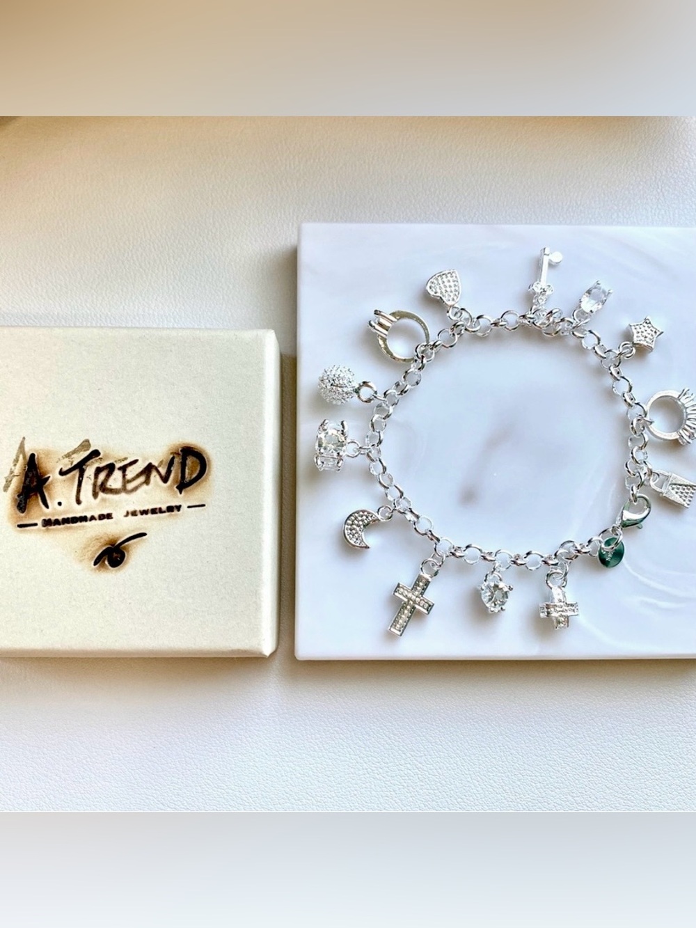 Silver charm bracelet with cross, moon, star, and other charms